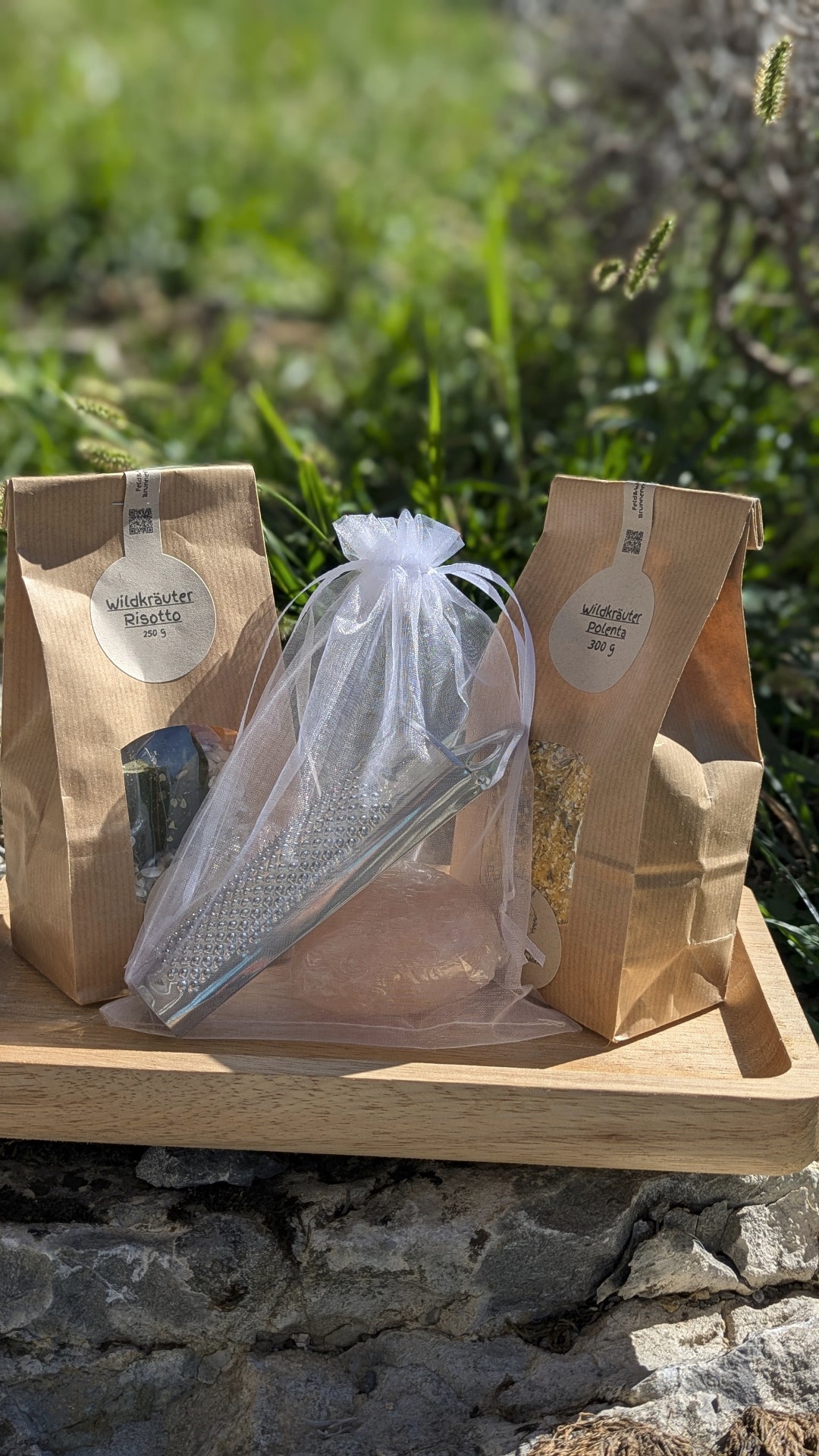Feld & Wiese Genusskorb mit Wildkräuter-Risotto, Wildkräuter-Polenta und Salzherz mit Reibe auf Holztablett in der Natur